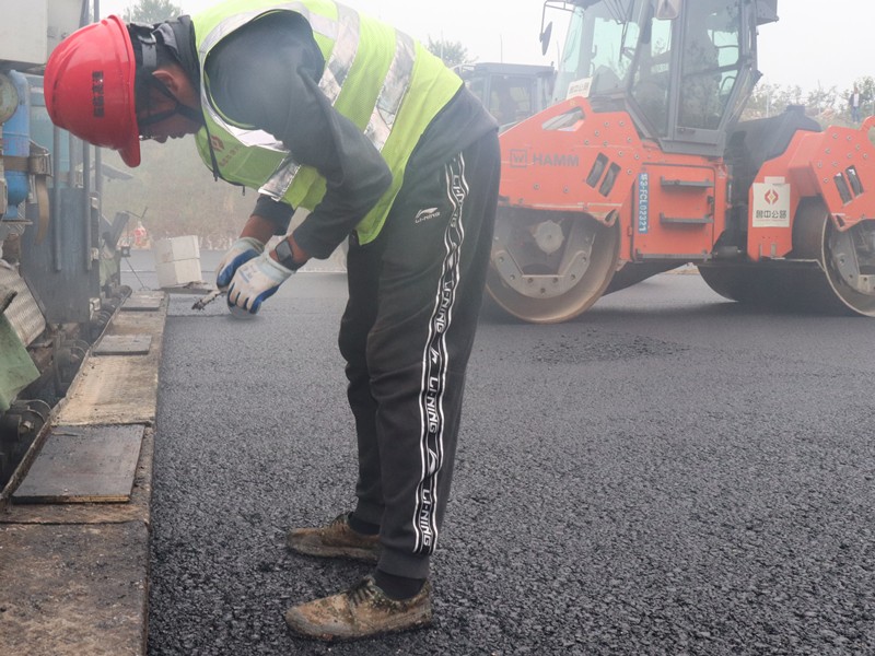 5、油層施工員任慶波隨時測量瀝青層松鋪厚度_副本